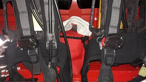 na zdjęciu pokazane są dwa aparaty powietrzne, umieszczone w kabinie samochodu pożarniczego. Do pasów podtrzymujących przymocowane są urządzenia zwane czujnikami bezruchu.