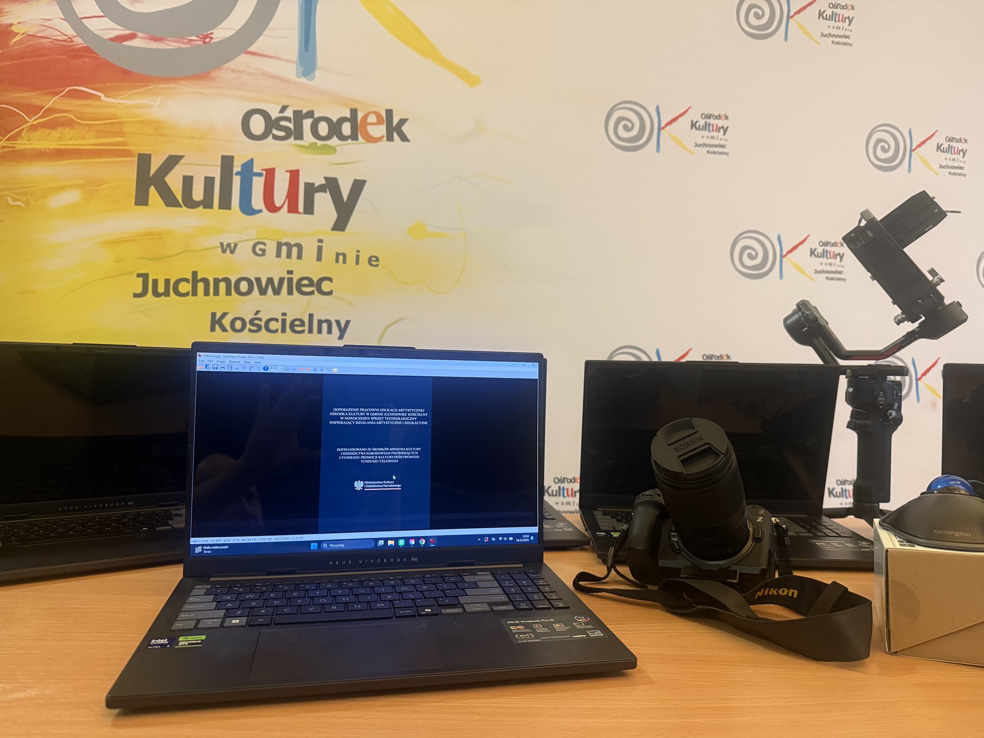zdjęcia przedstawiają sprzęt (laptopy, aparat fotograficzny, myszy komputerowe typu trackball) zakupione w ramach projektu „Doposażenie Pracowni Edukacji Artystycznej Ośrodka Kultury w Gminie Juchnowiec Kościelny w nowoczesny sprzęt technologiczny wspierający działania artystyczne i edukacyjne
