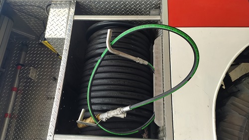 zdjęcie przedstawia lancę kominową zamontowaną do węża gumowego (tzw. szybkiego natarcia) w pożarniczym samochodzie ratowniczo-gaśniczym.